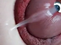 Sounding with a load of cum close-up through a penis plug