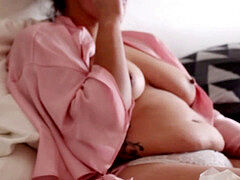 In sofa stuffing my face in a pink robe. My stomach and titts are getting so huge