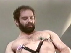 Hairy gay man strokes his big cock in retro fetish clip